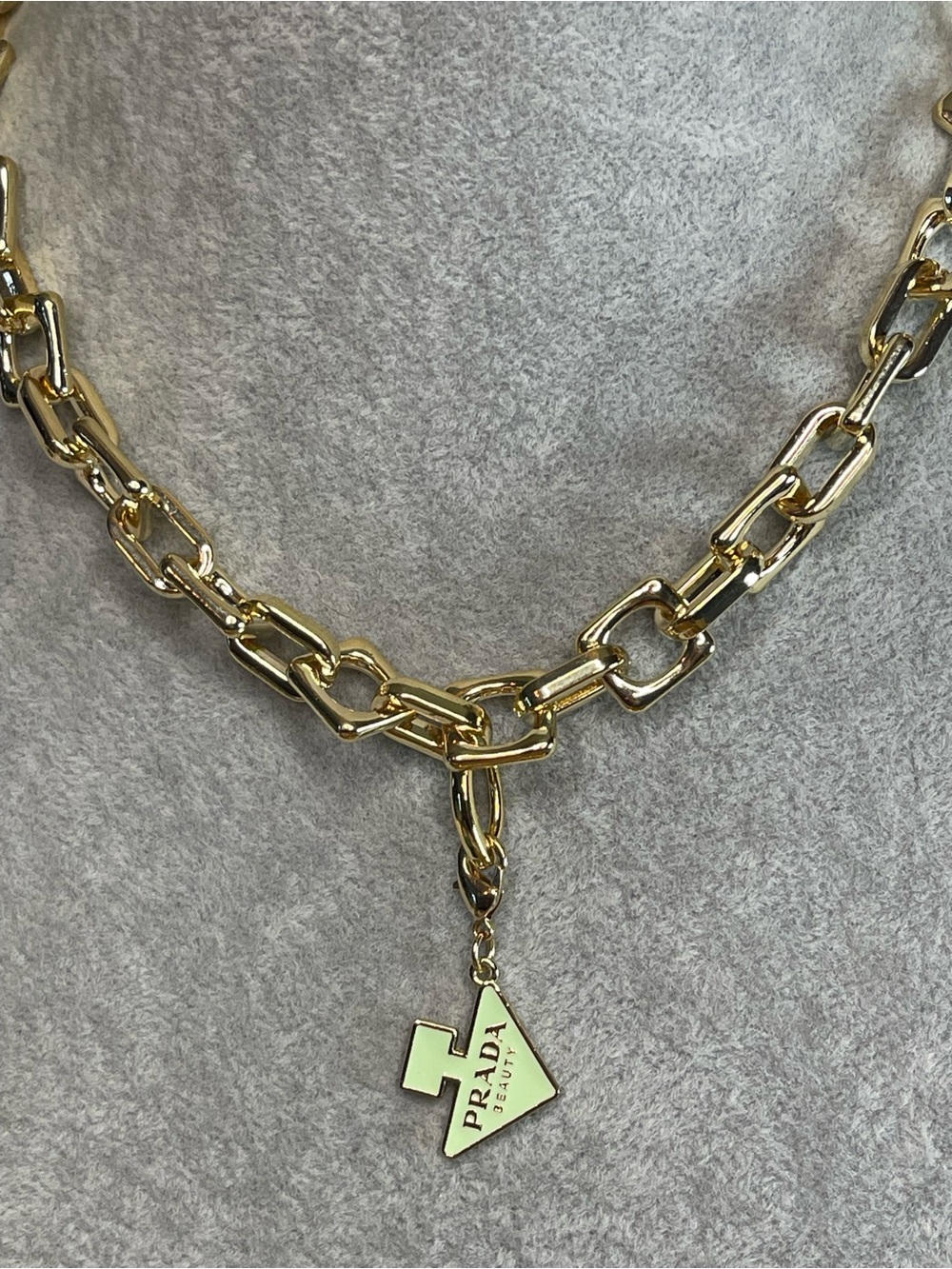 Gold tone chain with a Prada charm